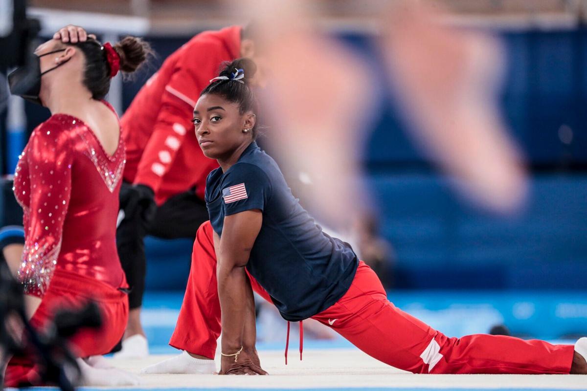 USA gymnast Simone Biles looks over to a competitor's practice as she warms up before competing in the Women's Balance Beam at Ariake Gymnastics Centre in Tokyo on Aug. 3, 2021.