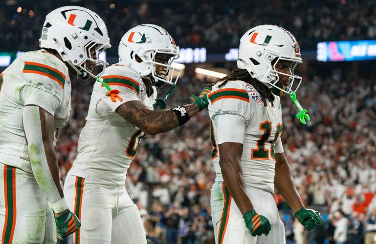 Miami Hurricanes wide receiver Keelan Marion (0) pats Malachi Toney (10) on the back after his touchdown during the CFP Fiesta