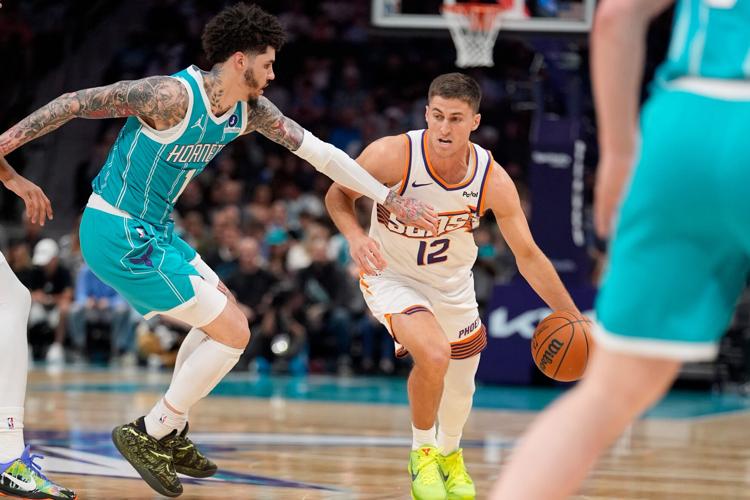 Phoenix Suns guard Collin Gillespie (12) brings the ball up court against Charlotte Hornets guard LaMelo Ball (1) during the first quarter at Spectrum Center in Charlotte, on April 2, 2026.