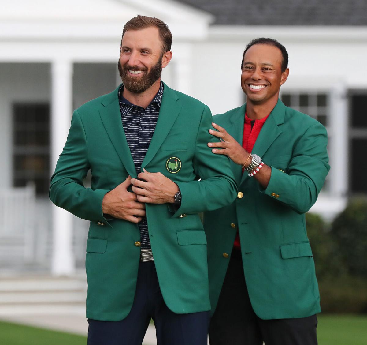 Tiger Woods presents Dustin Johnson with his green jacket after he won the Masters at Augusta National Golf Club on Sunday, November 15, 2020, in Augusta, Georgia.