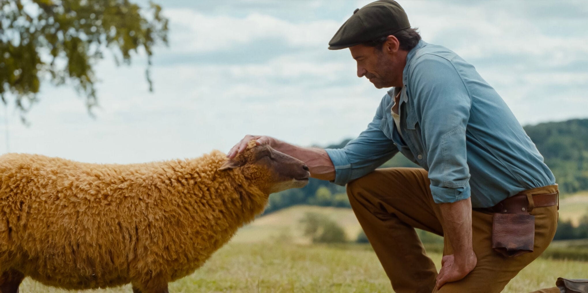 George (Hugh Jackman, right) pets his trusted sheep Lily (voiced by Julia-Louis Dreyfus) in the murder mystery "The Sheep Detectives."