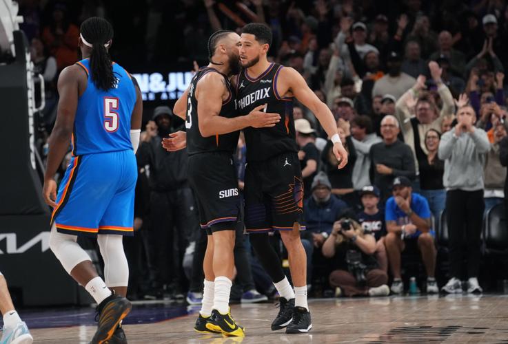 Phoenix Suns guard Devin Booker (1) embraces teammate Dillon Brooks (3) after making a 3-point shot to go up 108-105 against the Oklahoma City Thunder at Mortgage Matchup Center in Phoenix on Jan. 4, 2026.