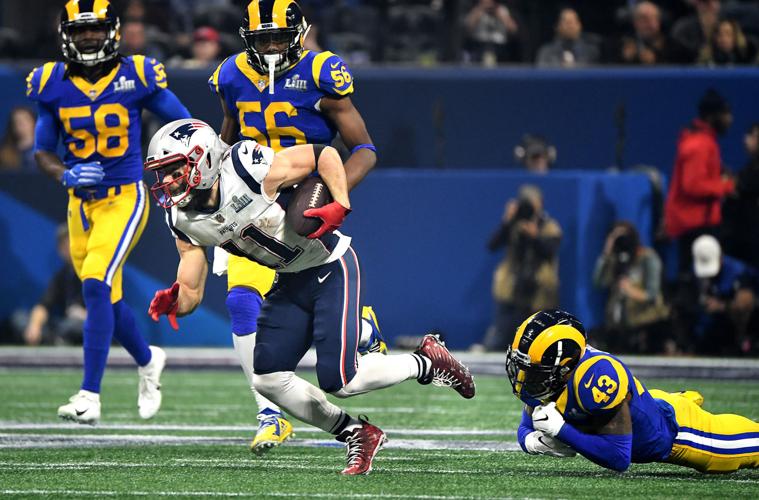 New England Patriots receiver Julian Edelman picks up big yards as he slips the tackle of the Los Angeles Rams' John Johnson in the third quarter in Super Bowl LIII at Mercedes-Benz Stadium in Atlanta on Sunday, Feb. 3, 2019. The Patriots won, 13-3.