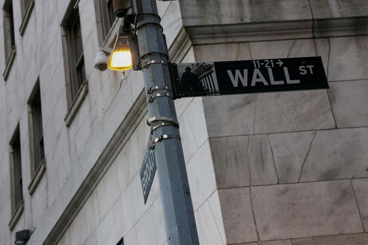FILE PHOTO: The Wall Street sign hangs outside the New York Stock Exchange (NYSE) building on Tuesday following Monday’s broad sell off in New York City