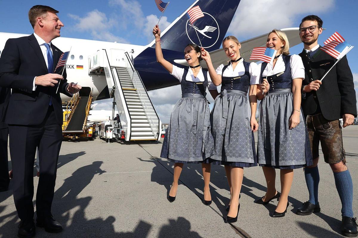 Timothy Liston, US Consul General in Munich, smiles with a Lufthansa Crew in traditional Bavarian costume next to her Airbus A 350-900 prior to a Lufthansa flight bound nonstop for Miami at Munich Airport on the first day that U.S. authorities are allowing tourists from Europe to enter the U.S. on Nov. 8, 2021 in Freising, Germany.