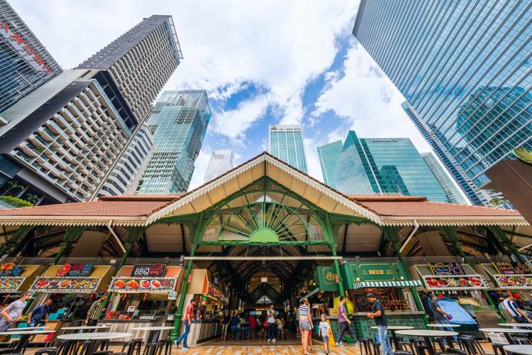 Lau Pa Sat Hawker Centre in a Victorian Singapore structure, surrounded by skyscrapers.