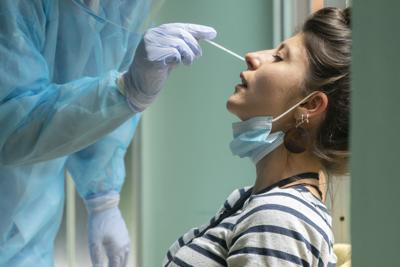 Healthcare Worker With Protective Equipment Performs Coronavirus Swab On Caucasian Girl.nose Swab Fo