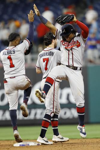 Atlanta Braves' Dansby Swanson, center, and Rafael Ortega, right