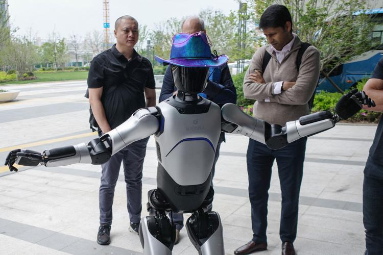 People interact with an Agibot RAISE A1 humanoid robot at the company's headquarters in Shanghai