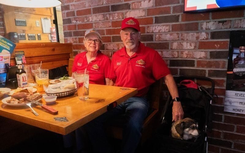 Judy and Mike McNamara sit at their table with their dog, Andy, June 25 at the Texas Roadhouse in West Des Moines.