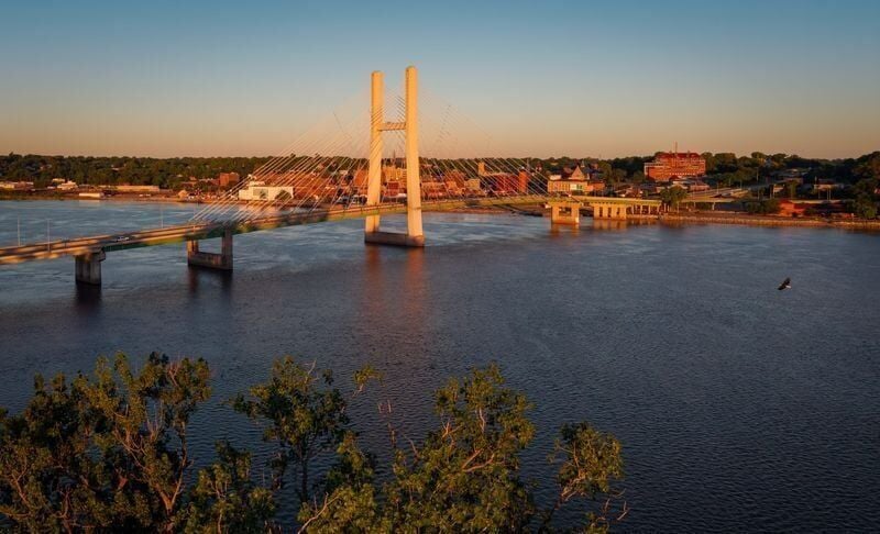 A Bald Eagle flies over the Mississippi River as the sun rises on Burlington, Iowa, June 12, 2026.