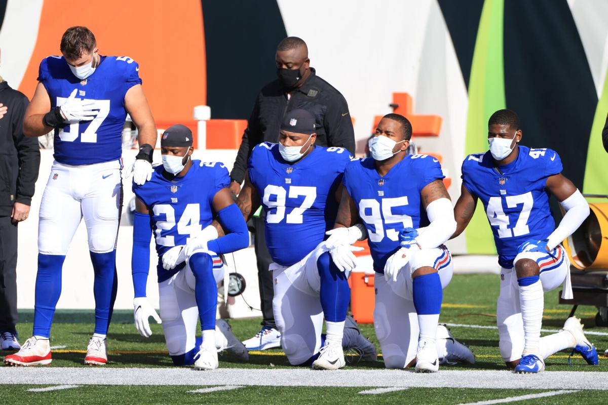 In this file photo, New York Giants players kneel wearing face masks during the National Anthem before the first half against the Cincinnati Bengals at Paul Brown Stadium on November 29, 2020 in Cincinnati, Ohio.