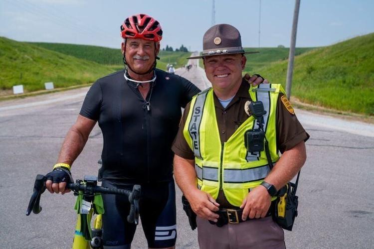Tait Williams reunites Sunday, July 19, 2026, on RAGBRAI with Iowa State Trooper Darren Flaherty. The veteran trooper used a defibrillator he carries in his cruiser to revive Williams, who suffered a near-fatal heart attack on RAGBRAI 2025 and now is ba...