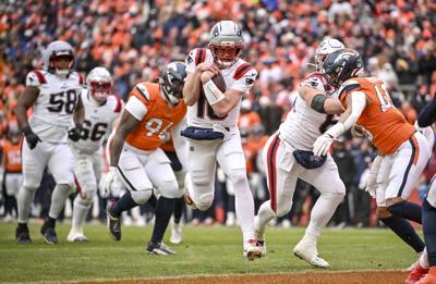 Drake Maye of the New England Patriots rushes in for a touchdown against the Denver Broncos during the second quarter at Empower Field at Mile High in Denver on Sunday, Jan. 25, 2026.