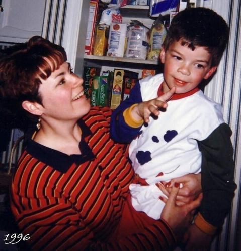 Leisa Walker holds her son, Sam, as he signs the word "mom" at six years old.