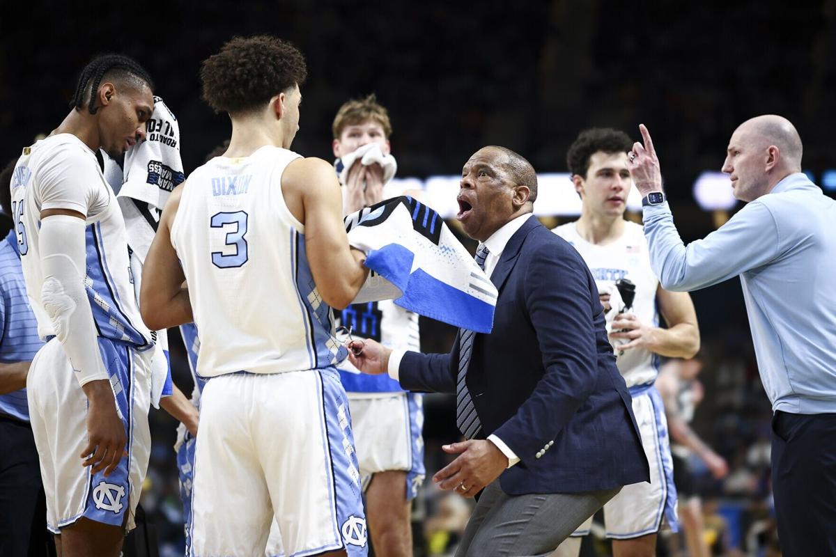 North Carolina head coach Hubert Davis reacts with Derek Dixon during a timeout in the second half against VCU in the first round of the NCAA Tournament at Bon Secours Wellness Arena on March 19, 2026, in Greenville, South Carolina.