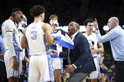 North Carolina head coach Hubert Davis reacts with Derek Dixon during a timeout in the second half against VCU in the first round of the NCAA Tournament at Bon Secours Wellness Arena on March 19, 2026, in Greenville, South Carolina.