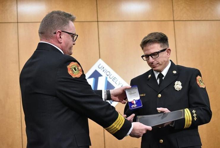 Urbandale Fire Chief Mike Cardwell, left, presents Battalion Chief Mike Gentosi with the Medal of Valor during a ceremony at Urbandale City Hall on April 7, 2026.