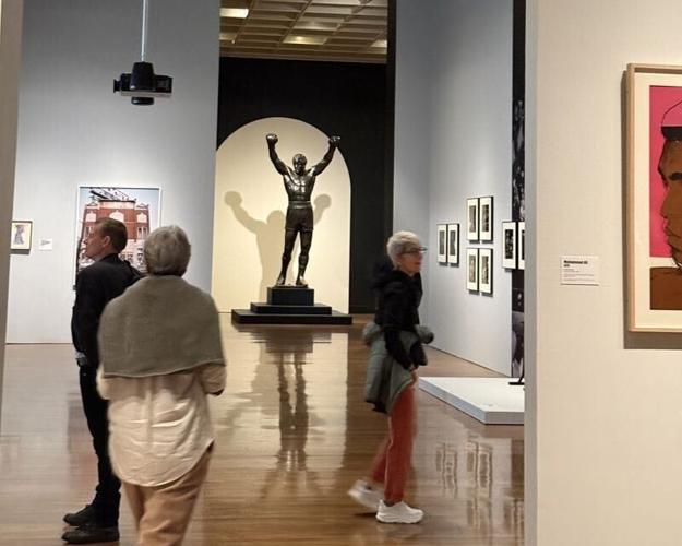 Visitors view Tom Schomberg’s “Rocky” statue inside the Philadelphia Museum of Art as part of the exhibition “Rising Up: Rocky and the Making of Monuments.”