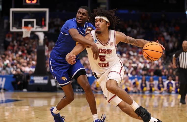 Alabama forward Amari Allen (5) drives against Hofstra guard Cruz Davis (5) during the first round of the 2026 NCAA men's tournament at Benchmark International Arena.