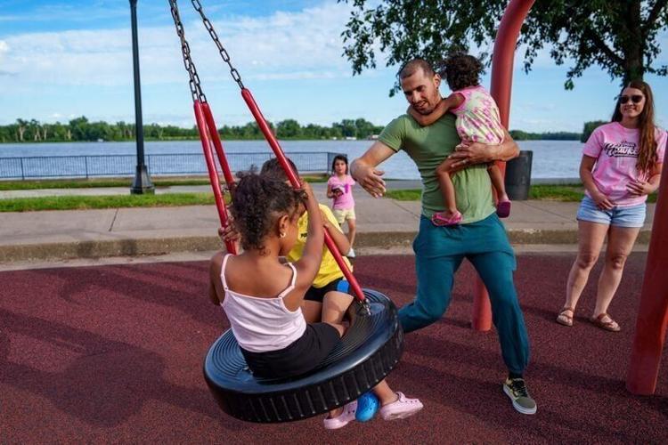 Juan F. Sierra Santiago pushes his kids on a tire swing at Riverside Park, June 15, 2026, in Muscatine, Iowa.