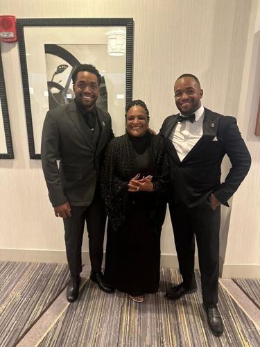 Quentin (left) and Quinlan Riser pose for a picture with their mother, Tina Johnson. The Riser brothers co-authored the book "Eden's Money Magic: Learning About Finances", which teaches children financial literacy.