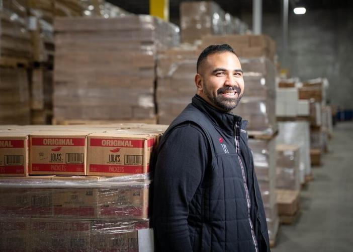 Taufeek Shah, the CEO of Des Moines-based Lola's Fine Sauces, stands for a photo at the company warehouse in Altoona, Tuesday, Nov. 29, 2022.