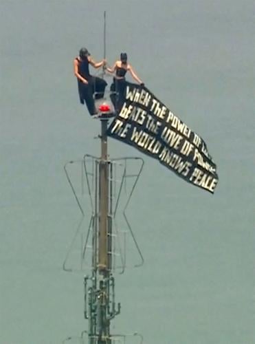 Two people display a banner atop the Empire State Building in the Manhattan borough of New York