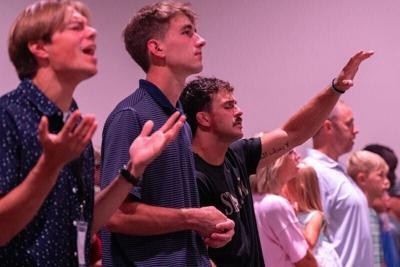 Jon Cardo, center, and other congregants sing worship songs Aug. 2, 2026 at The Acreage Church in West Union, Iowa.