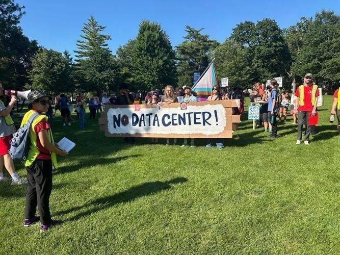 More than 100 protestors marched from Bandshell Park to Ames City Hall on Tuesday, July 14, as the City Council prepared to consider a proposed 100,000-square-foot data center at James Herman Banning Ames Municipal Airport.