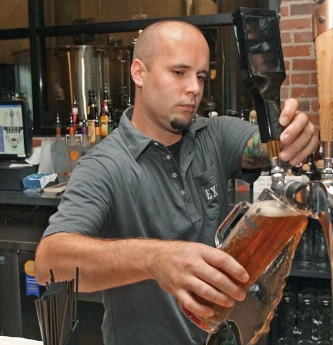 Bartender Brad Berkley, of Clive, poured a Maibock beer during opening weekend at Exile Brewing Company, 1514 Walnut St., Des Moines, on Friday, Aug. 10, 2012.