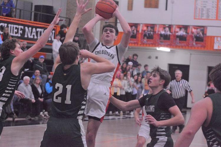 Cheboygan junior guard Gavin Smith (middle) shoots over multiple Grayling defenders during the first quarter of an MHSAA Division 2 boys basketball district semifinal in Cheboygan on Wednesday, Feb. 25.