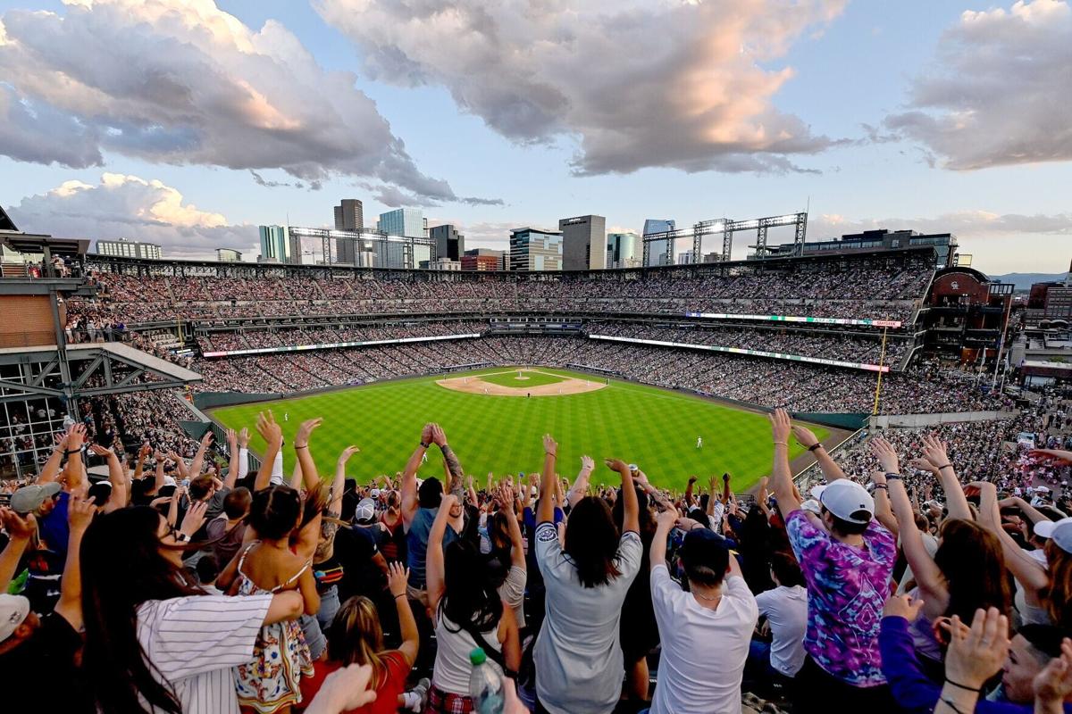 Fans in the outfield bleacher Rockpile section of Coors Field stand for the wave during action between the Colorado Rockies and the Milwaukee Brewers on July 4, 2024 in Denver, Colorado.