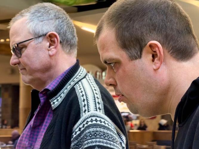 Sam Walker and his father, Kent, choose a drink from the vending machine together while visiting Jordan Creek Town Center on Feb. 26, 2026, in West Des Moines. After the Walker family’s managed care company informed them their son’s benefits would be cu...