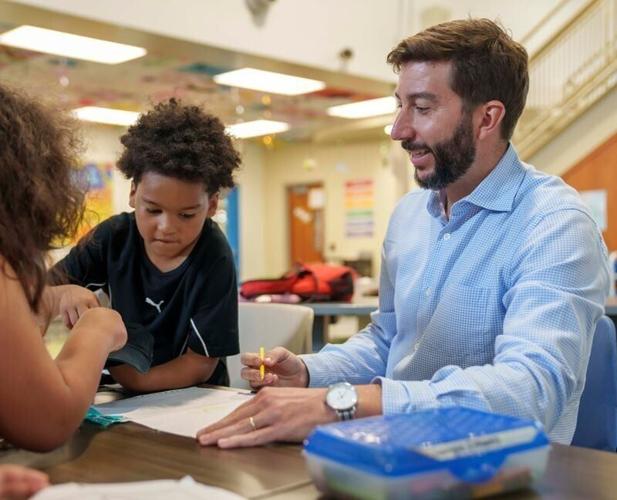 Tanner Krause spends time coloring and talking with children at the Boys & Girls Club of Central Iowa Wednesday, June 10, 2026, in Des Moines. Krause is taking on the interim CEO role until the position can be filled permanently.