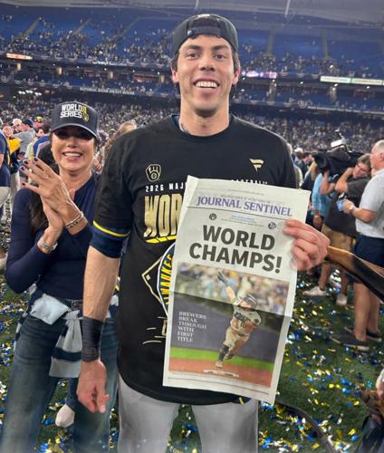 The Milwaukee Brewers Milwaukee Brewers designated hitter Christian Yelich (22) holds up a Milwaukee Journal Sentinel “World