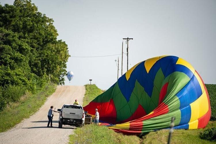 Balloon pilot Aaron Gebhart and crew members pack up the balloon StepNUp during the 2025 National Balloon Classic on July 29, 2025, outside of Milo, Iowa.