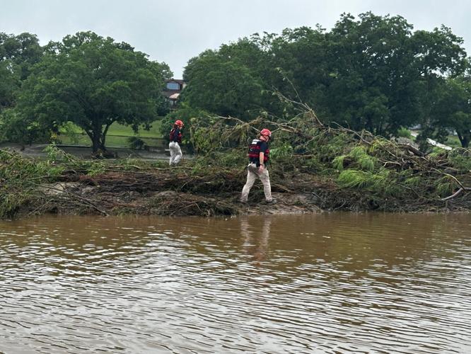 TEXSAR search-and-rescue volunteers scour the banks of the Guadalupe River, looking for victims of the recent floods. The group has deployed 50 volunteers and six swift-water rescue boats to help search for victims.