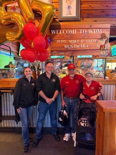Mike and Judy McNamara pose with staff June 24 at the Texas Roadhouse in West Des Moines.