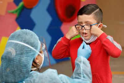 Kindergarten student Matteo Rodriguez gets a Covid-19 test from EMT Claire Chou on April 13, 2021, in Maywood, California..