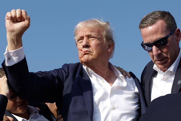 Republican presidential candidate former President Donald Trump pumps his fist as he is rushed offstage by Secret Service agents after being grazed by a bullet during a campaign rally on Saturday, July 13, 2024, in Butler, Pennsylvania.