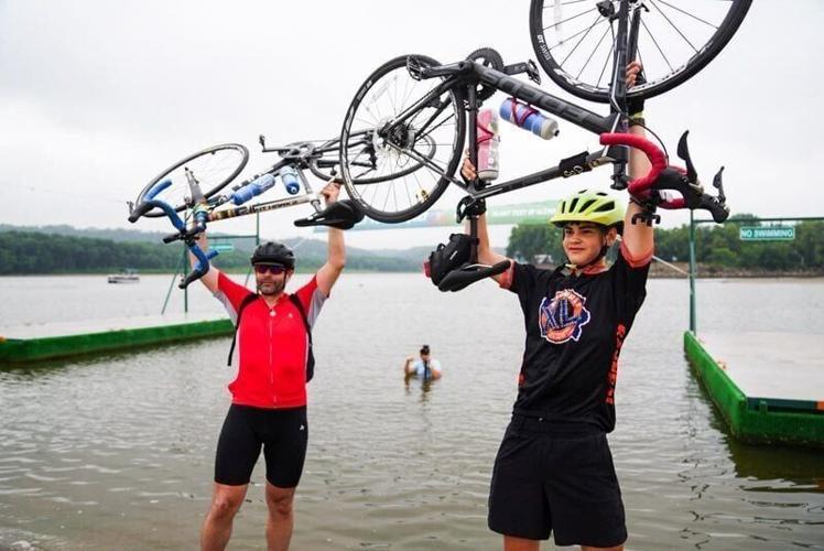 Desmond and Nick Smith of Iowa City raise their bikes above their head on the last day of RAGBRAI, Friday, July 25, 2026, in Dubuque.