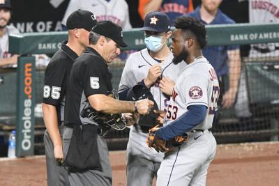 Home plate umpire Angel Hernandez checks the hat of Houston Astros pitcher Cristian Javier for substances during a game against the Baltimore Orioles at Oriole Park at Camden Yards on June 21, 2021, in Baltimore.