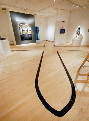 “Drone Shadows” by James Bridle stretches across the gallery’s floor.
