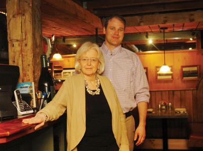 Kathy Kneale and her son, Andrew Kneale, stand in Harrison’s Restaurant, which the family has operated for more than a decade.