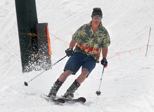 A skier makes his way back to the Quad lift in melting snow at Mount Mansfield on Monday.