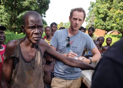 Lewis Mudge, right, conducts interviews on village attacks