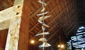 A sculpture by Jane Parkes hangs amid timbers and barnboard.