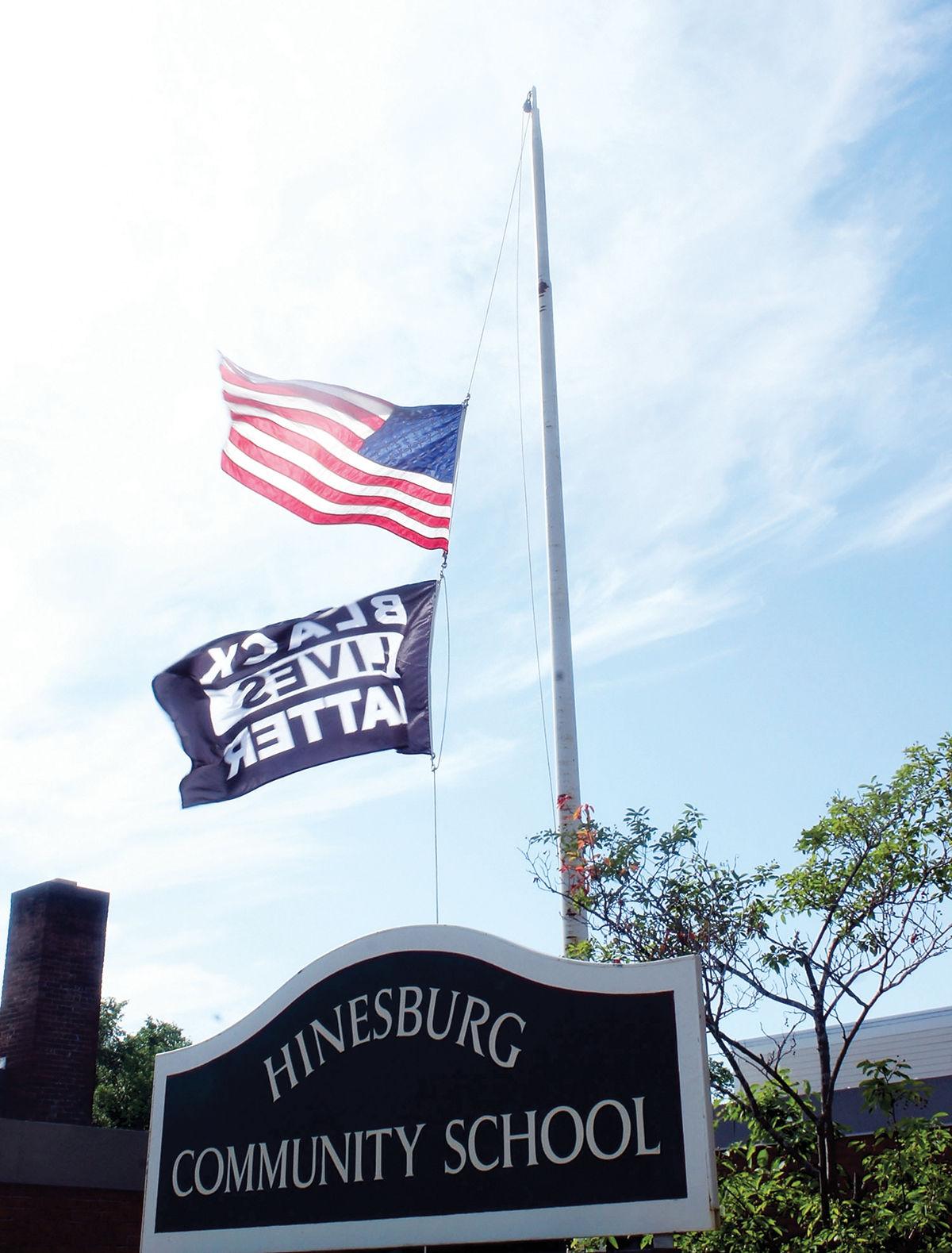 The Black Lives Matter and United States flags fly at half mast