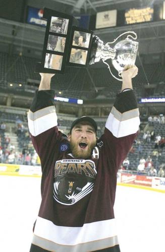 Graham Mink holds up a trophy while playing for the Hershey Bears.